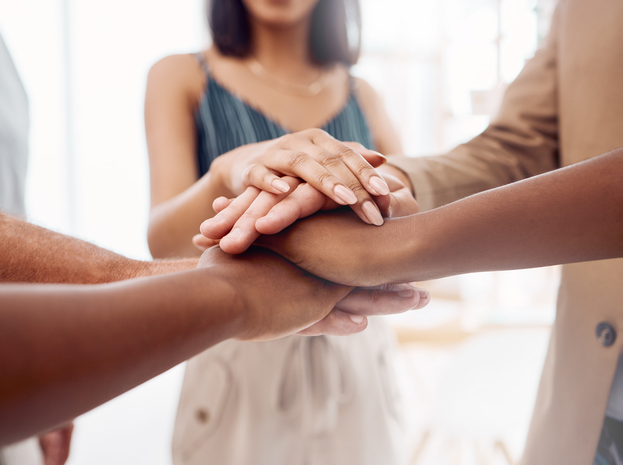 A team placing their hands together