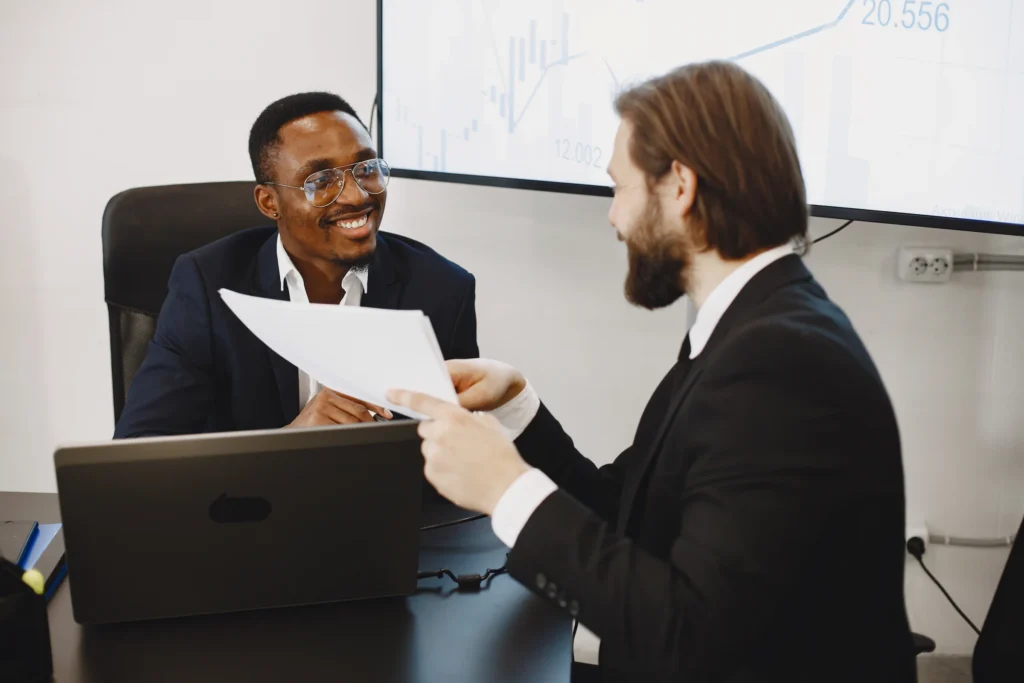Two business professionals reviewing a document together across an office desk